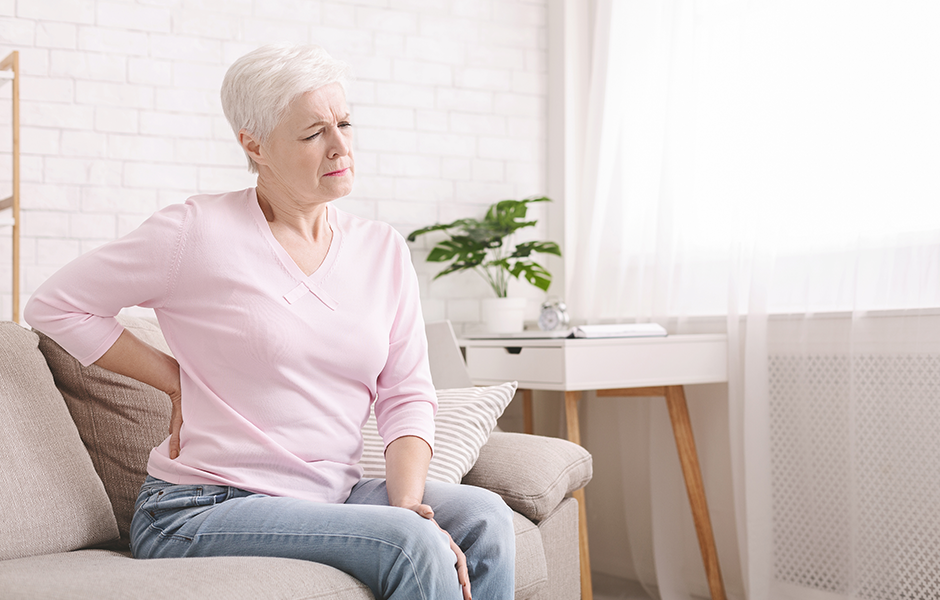 Woman sitting on couch with back pain